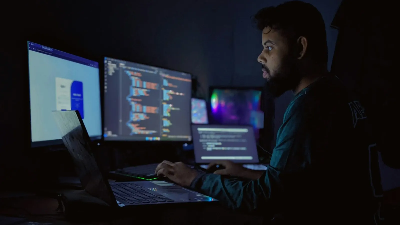 Developer working in front of several monitors with code