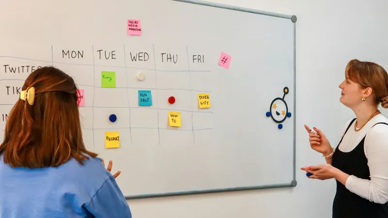 Marketing team planning content on a whiteboard with sticky notes