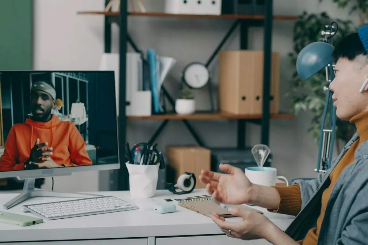 Two people working at a desk with a computer